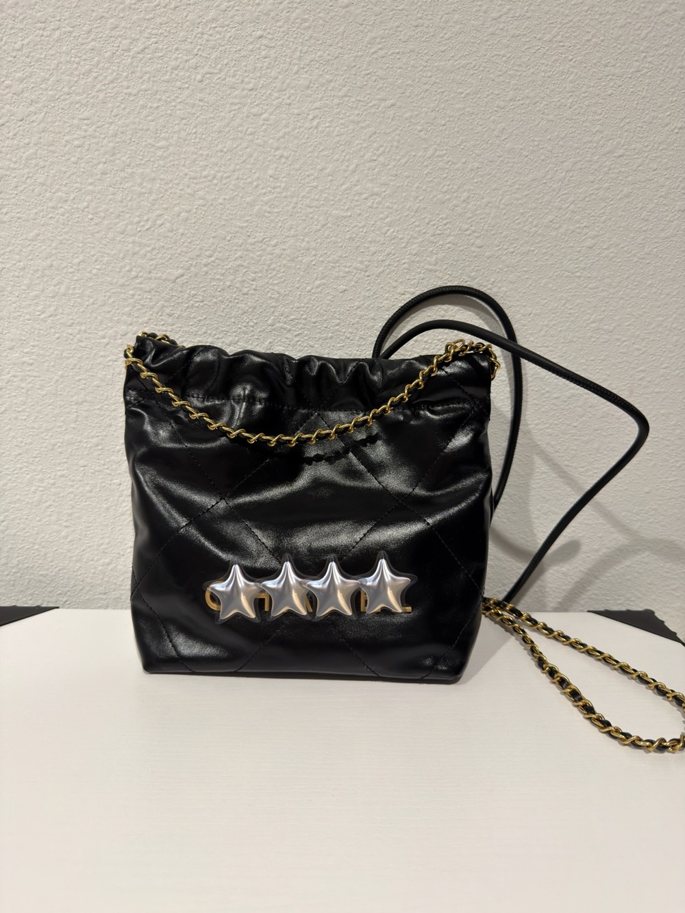 Black Quilted Drawstring Crossbody Bag with Gold Chain & Gold Accents